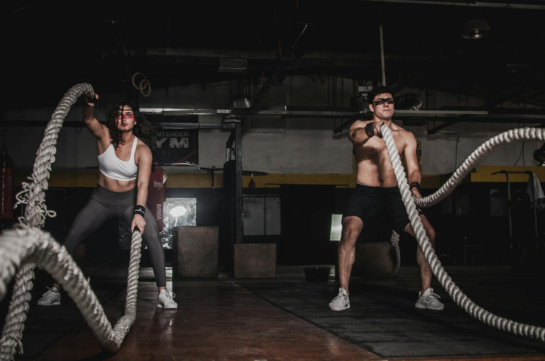 Atletas entrenando con battle ropes en gym oscuro — Ashwagandha KSM-66 Epic Labs